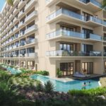 A modern multi-story resort with balconies overlooks a lush tropical garden and a winding pool. People relax in the water and on lounge chairs. Palm trees surround the building, creating a serene and inviting atmosphere.